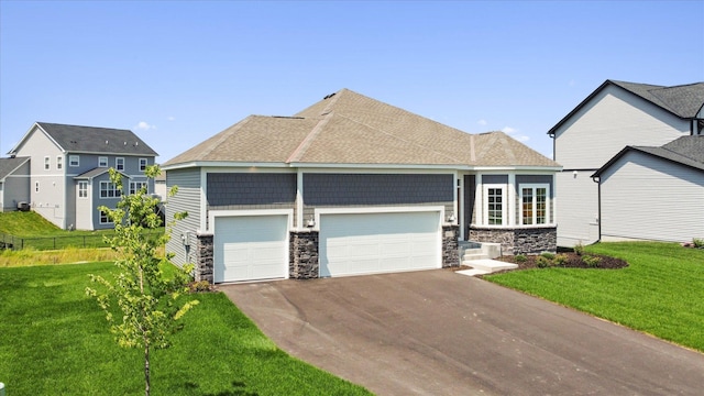 view of front of property featuring an attached garage, fence, a front yard, stone siding, and driveway