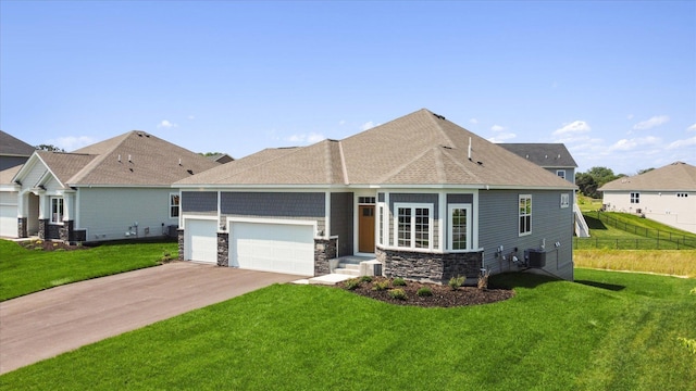 view of front of house with a front yard, an attached garage, stone siding, and driveway