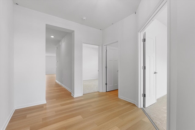 hallway with baseboards and light wood-style floors