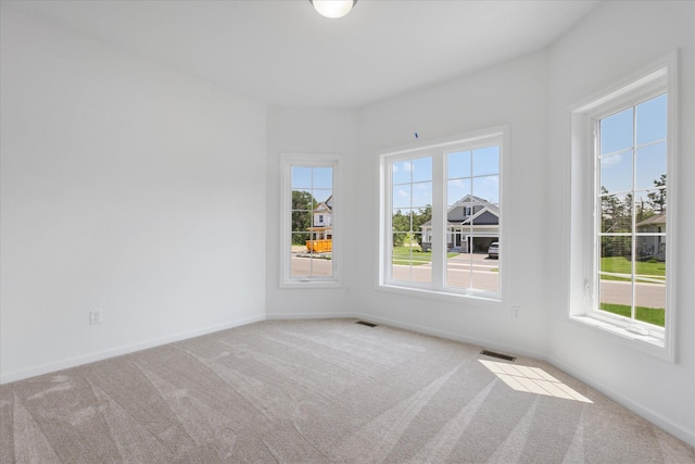 unfurnished room with visible vents, baseboards, and carpet