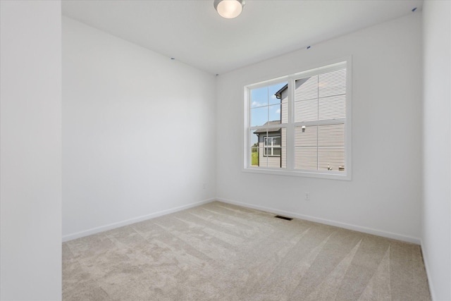 spare room with visible vents, baseboards, and carpet