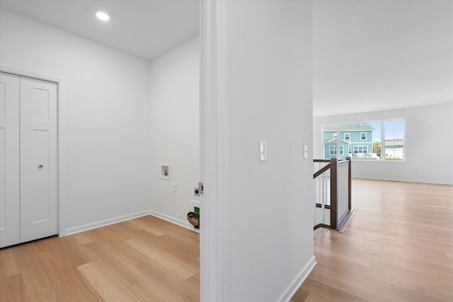 washroom with electric dryer hookup, light wood-type flooring, hookup for a washing machine, and laundry area