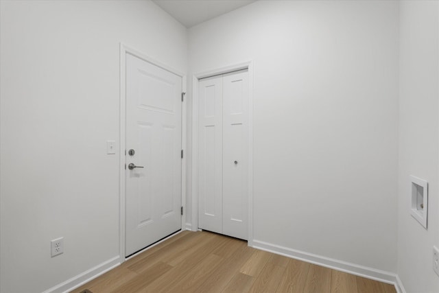 interior space featuring light wood-type flooring and baseboards