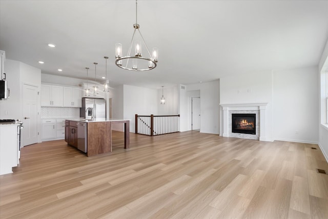 kitchen featuring light countertops, a notable chandelier, open floor plan, and appliances with stainless steel finishes