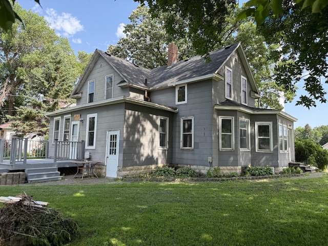902 Pacific Ave, Kerkhoven, MN 56252 - rear view of property featuring a chimney, a yard, a deck, and a shingled roof