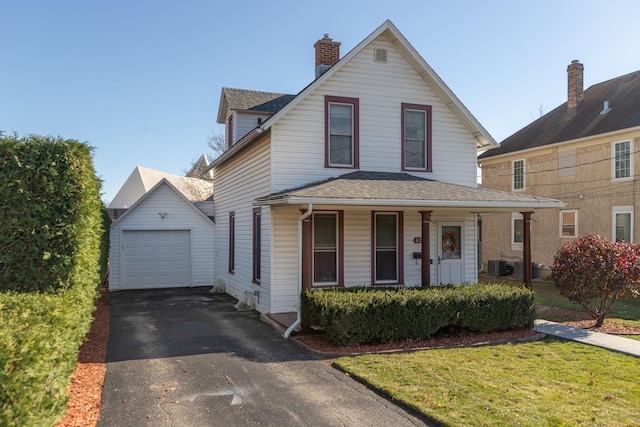 view of front facade with an outbuilding, central AC unit, driveway, and a shingled roof