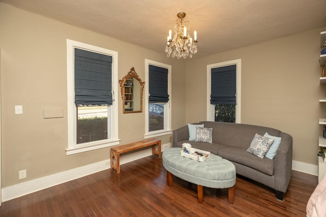 living area with baseboards, an inviting chandelier, and wood finished floors