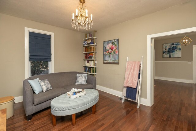 sitting room with a chandelier, baseboards, and wood finished floors