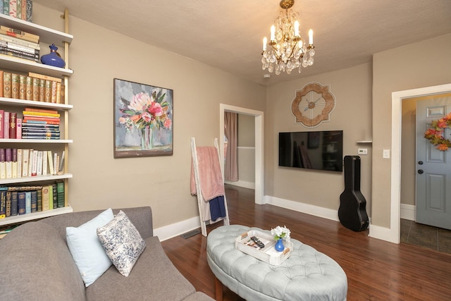 living room featuring an inviting chandelier, wood finished floors, baseboards, and visible vents