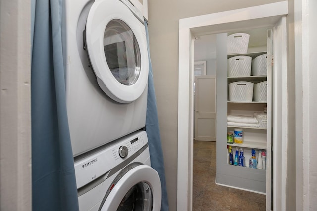 clothes washing area with stacked washer / dryer and laundry area