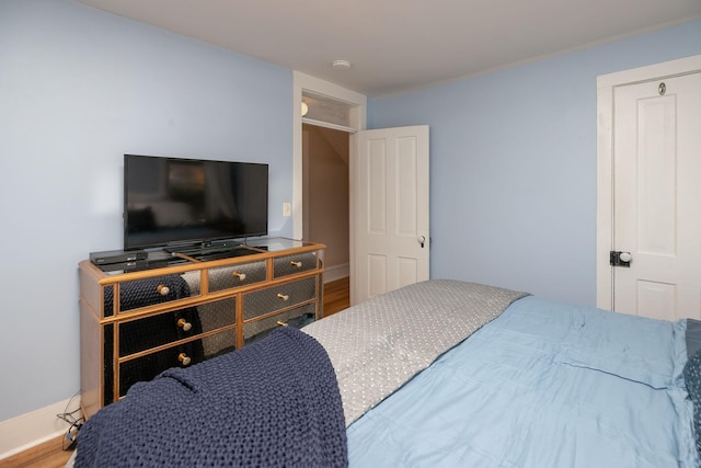 bedroom with baseboards and wood finished floors