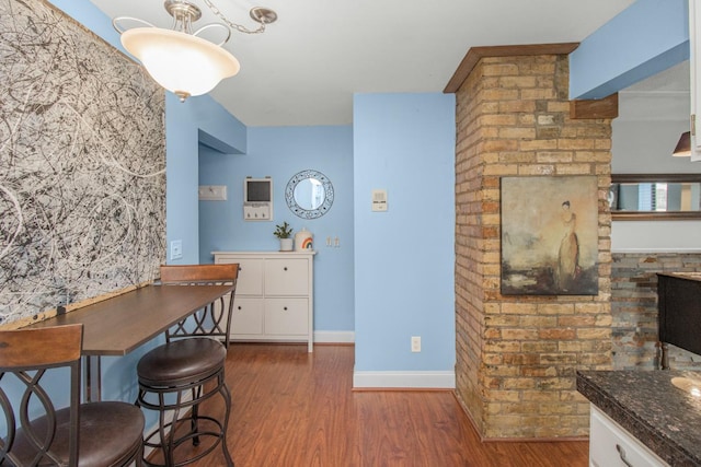 dining space featuring wood finished floors and baseboards