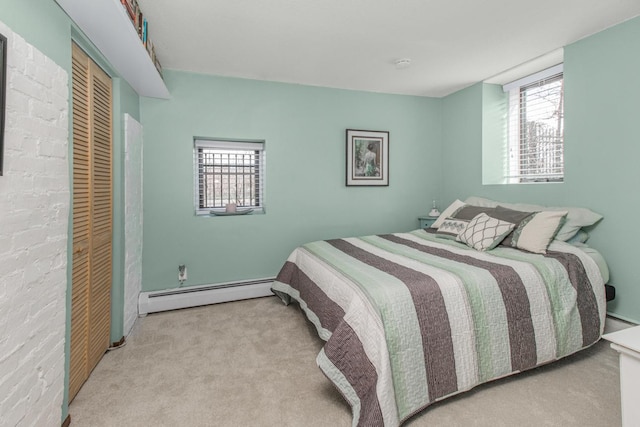 bedroom featuring a baseboard heating unit, carpet flooring, a closet, and baseboard heating