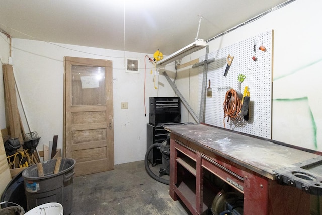 miscellaneous room with a workshop area and concrete floors