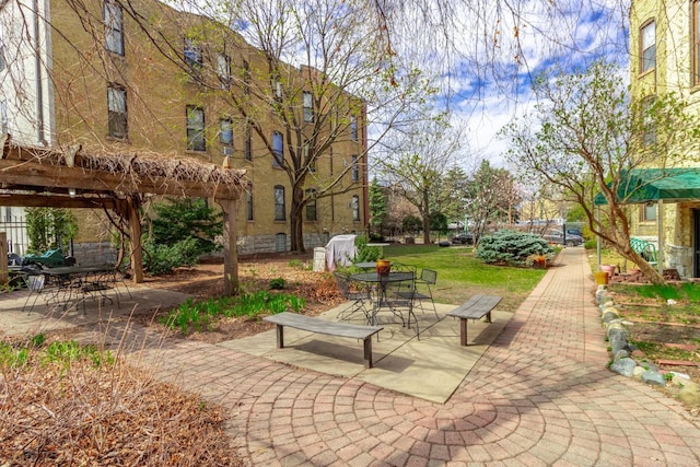 view of property's community with outdoor dining area and a patio area