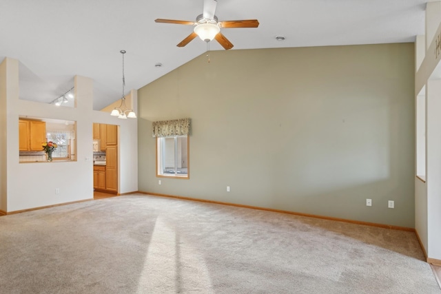 unfurnished living room featuring baseboards, light carpet, high vaulted ceiling, and ceiling fan with notable chandelier