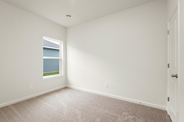 empty room featuring carpet flooring and baseboards