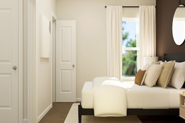 bedroom with baseboards and dark colored carpet