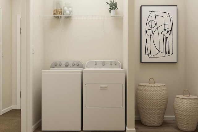 clothes washing area with baseboards and independent washer and dryer