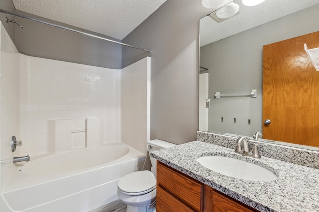 bathroom featuring toilet, a textured ceiling, vanity, and  shower combination