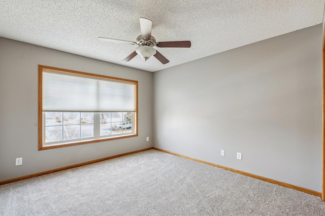 carpeted empty room with baseboards, a textured ceiling, and ceiling fan