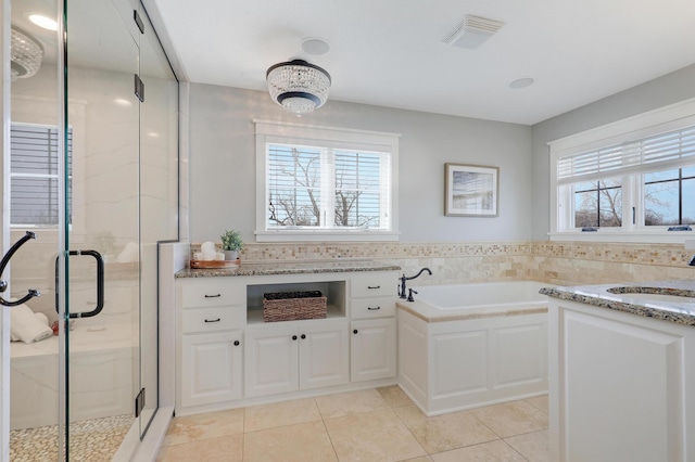 full bathroom with a wealth of natural light, a stall shower, and a sink