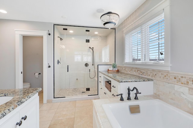 full bathroom featuring vanity, a garden tub, a stall shower, and tile patterned floors