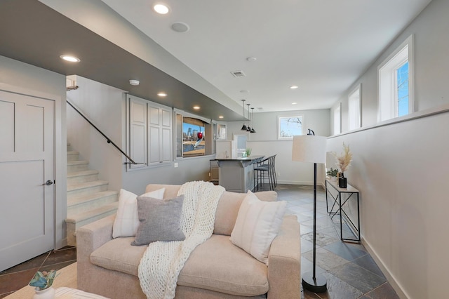 living area featuring visible vents, recessed lighting, baseboards, and bar