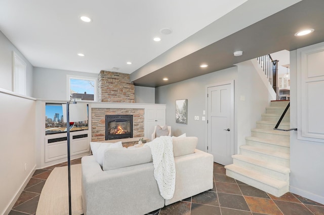 living area with a stone fireplace, recessed lighting, stairs, and baseboards