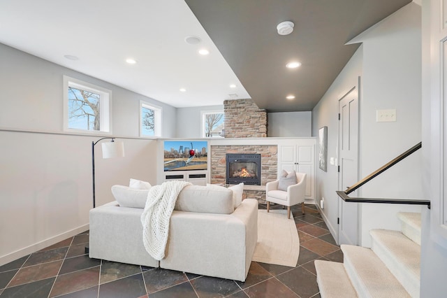 living area featuring a stone fireplace, recessed lighting, stairs, and baseboards