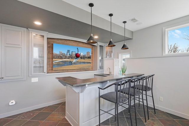 kitchen featuring glass insert cabinets, a breakfast bar area, and white cabinetry