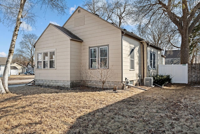 view of side of property with central AC unit and fence