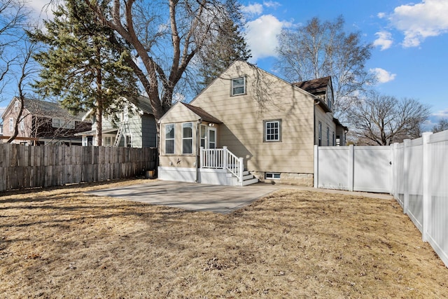 rear view of house featuring a fenced backyard and a patio area