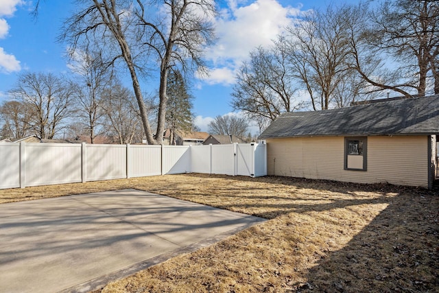 view of yard with a gate, a fenced backyard, and a patio area