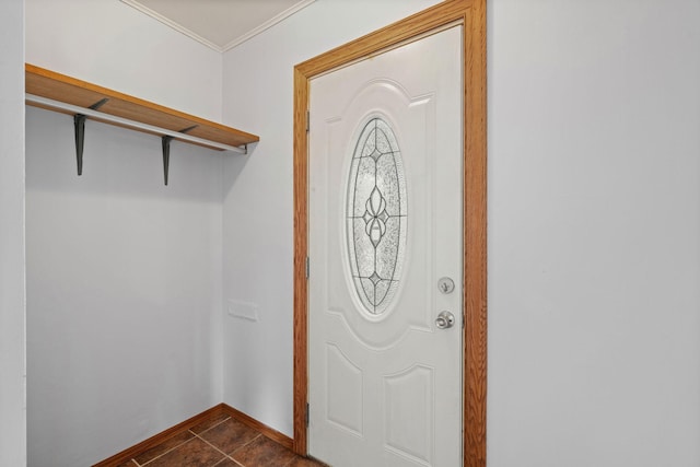 entryway featuring baseboards, dark tile patterned floors, and crown molding