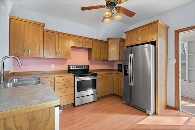 kitchen with light wood finished floors, ceiling fan, brown cabinets, stainless steel appliances, and a sink