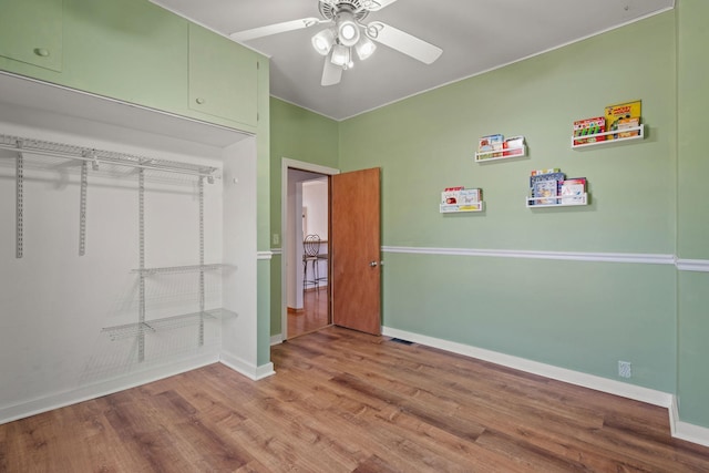 unfurnished bedroom featuring a ceiling fan, baseboards, and wood finished floors