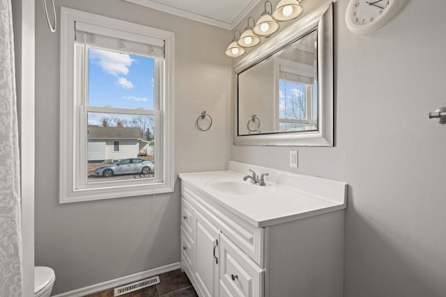 bathroom with vanity, baseboards, visible vents, crown molding, and toilet