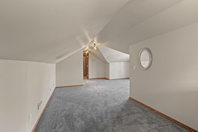 additional living space featuring visible vents, baseboards, lofted ceiling, and carpet flooring