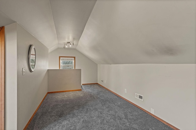 bonus room with carpet flooring, baseboards, lofted ceiling, and visible vents