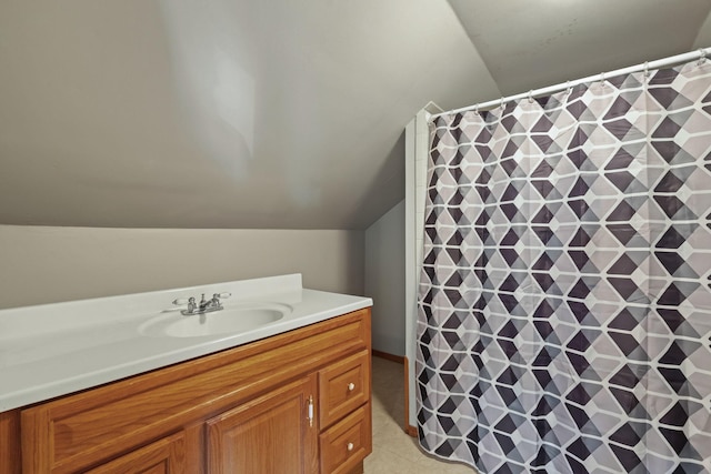 bathroom with curtained shower, lofted ceiling, vanity, and tile patterned flooring