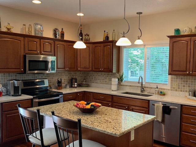 kitchen featuring a breakfast bar, a sink, decorative backsplash, stainless steel appliances, and a center island