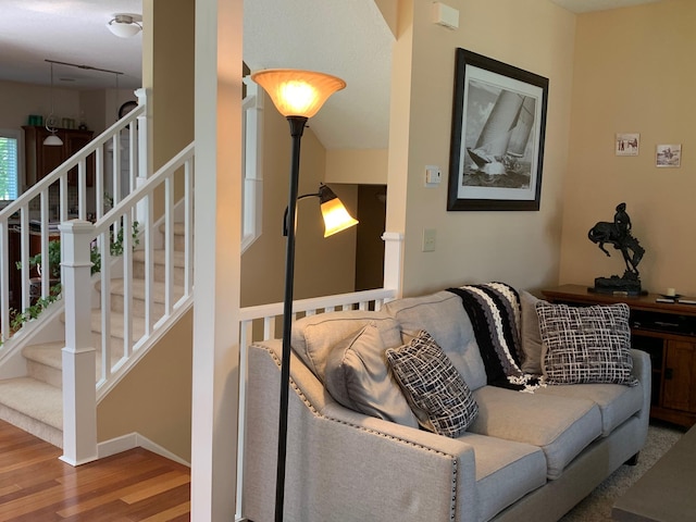 living room with stairs, baseboards, and wood finished floors