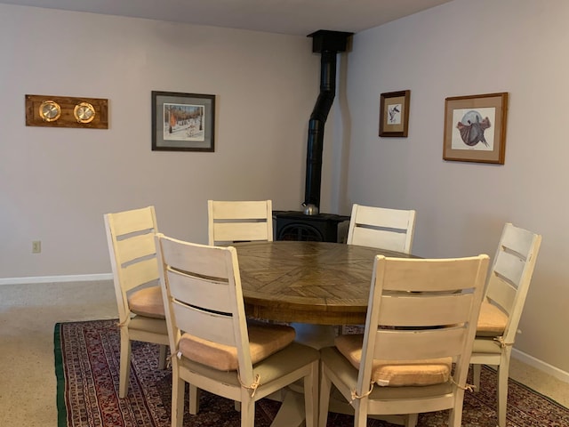 dining area with a wood stove and baseboards