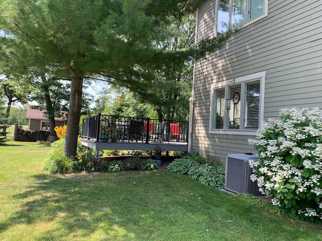 view of yard with central AC and a wooden deck