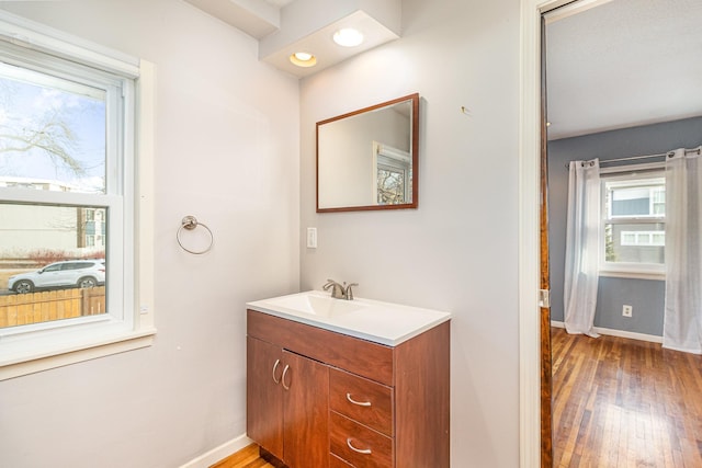 bathroom featuring vanity, wood finished floors, and baseboards