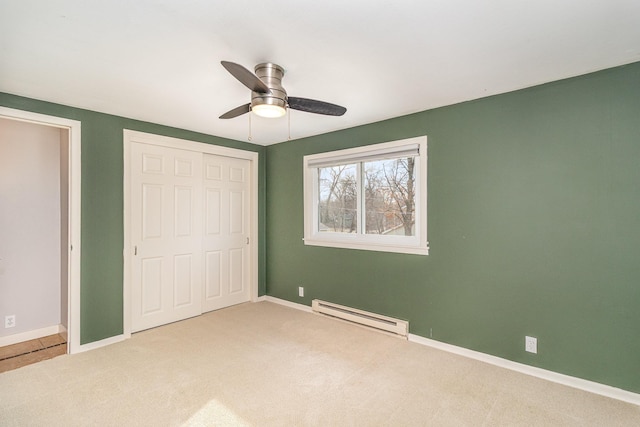 unfurnished bedroom featuring baseboards, carpet floors, baseboard heating, and a closet