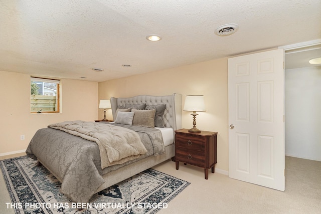 bedroom with visible vents, light colored carpet, a textured ceiling, and baseboards