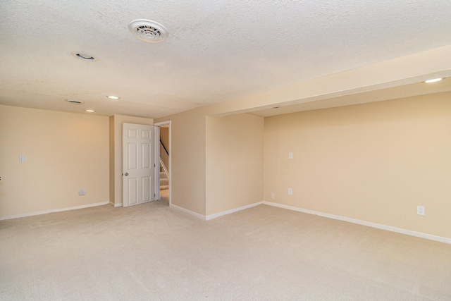 spare room featuring light carpet, visible vents, stairs, and baseboards