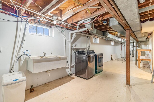 below grade area with a sink and washing machine and clothes dryer